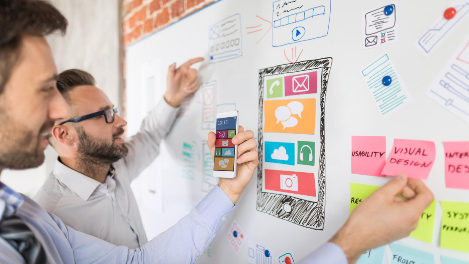 team discussing and brainstorming blog design concept on a whiteboard in an office setting