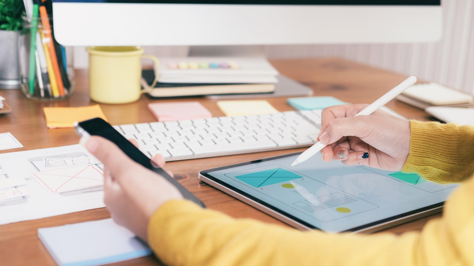 focused person drawing website ad space on a computer screen determined as they sketch out the design