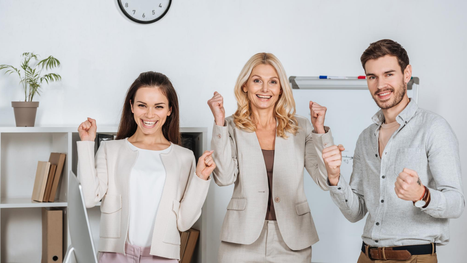 group of people stands together, their faces lit up with excitement as they discuss their plans for coaching their clients